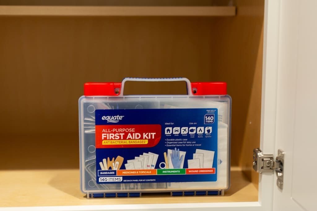 Une boîte de rangement étiquetée « Trousse de premiers secours polyvalente Equate », dotée d’une poignée et contenant divers articles de premiers secours.
