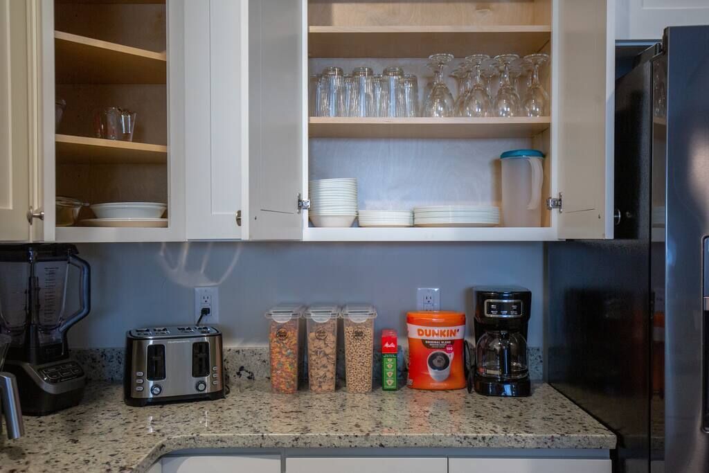 A kitchen with a toaster, coffee maker, and spice jars on the counter.