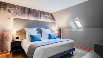 Un dormitorio moderno con una cama grande, una mesita de noche, una lámpara de pared y un tragaluz.