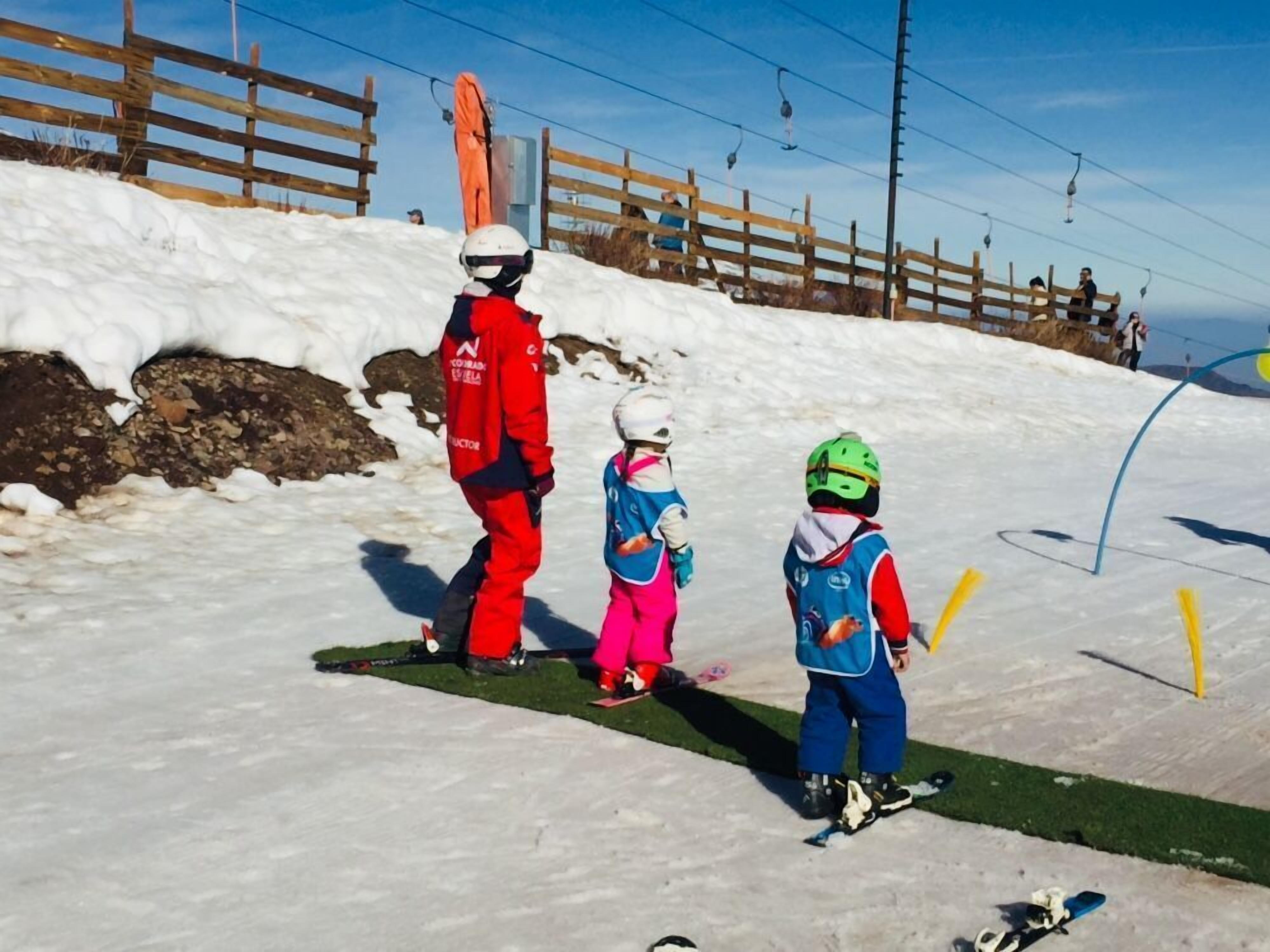 Pista de esquí nevada con vallas de madera y un telesilla al fondo.