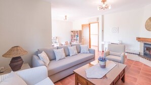 A living room with a sofa, armchairs, a coffee table, and a fireplace. - Casa Sierra Alhaurín de la Torre by Ruralidays (Málaga)