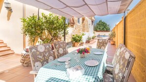 An outdoor patio with a checkered table set for dining, surrounded by chairs with floral upholstery. - Casa Sierra Alhaurín de la Torre by Ruralidays (Málaga)