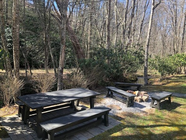 A picnic area with wooden tables and benches surrounded by trees. - Creekside cabin w/ hot tub, fireplace & trail (Newland)