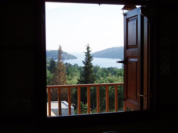 A room with a view of a lake and mountains.