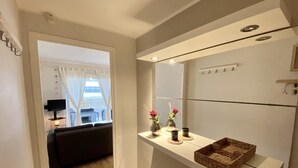 Een moderne badkamer met een spiegel, een plank met decoratieve objecten en een houten vloer.