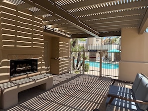 A covered outdoor area with a pool, a sign indicating pool closing time, and a bench. - Resort style Living in Scottsdale (Scottsdale)