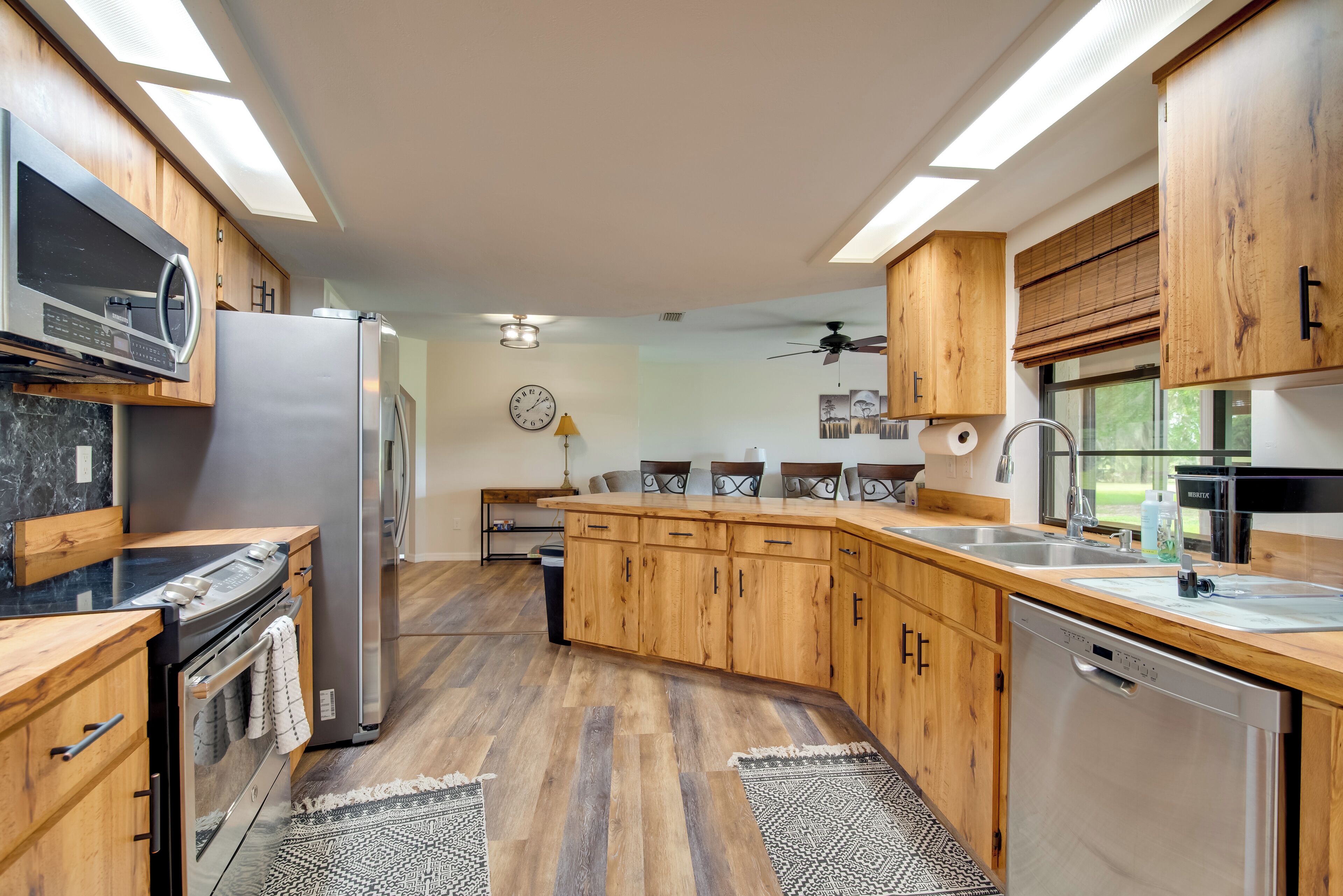 A modern kitchen with wooden cabinets, stainless steel appliances, and a large island.
