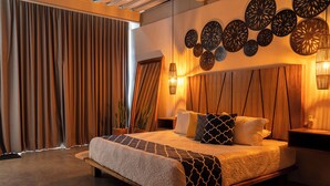 Een moderne slaapkamer met een groot bed, een houten hoofdbord en decoratieve wandkunst.