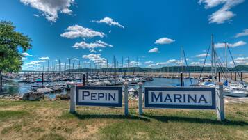 A marina with boats docked, two signs reading 'PEPIN' and 'MARINA', and a clear blue sky.