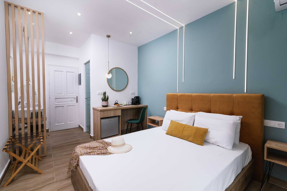 A modern hotel room with a bed, desk, and chair.