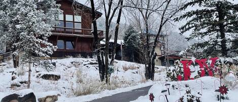 A snow-covered landscape with a wooden cabin and a sign indicating the year 2015.