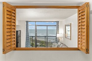 Enjoy ocean views from the comfort of your room, featuring a large window, balcony, and stylish decor.