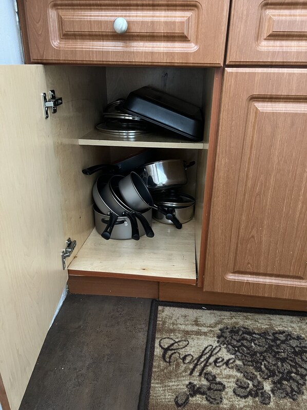A kitchen cabinet with a built-in shelf containing cookware and a small wooden shelf below. - Beach Design place to relax,nice restaurants near by,enjoy your stay (Miami)