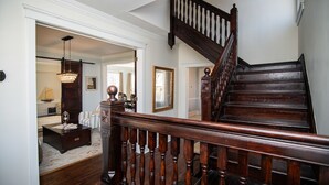 A wooden staircase with a balustrade leading to a second-floor landing.