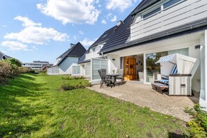 Il s’agit d’une propriété résidentielle dotée d’un patio couvert, d’un espace extérieur aménagé pour s’asseoir et d’une pelouse bien entretenue.