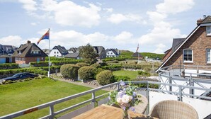 Een woonwijk met huizen, een vlag en een gazon.
