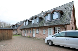 A two-story brick house with a sloped roof and dormer windows.