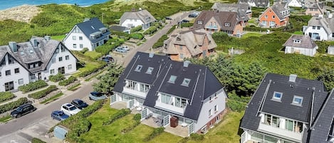 Zona residencial con casas, una carretera y vista al mar.