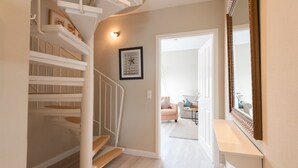 Ein modernes Interieur mit einer Wendeltreppe, einem gerahmten Bild an der Wand und einem Spiegel.