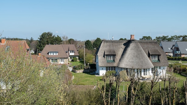 Un quartier résidentiel où les maisons se distinguent par leurs toits de chaume et leur architecture traditionnelle.