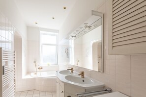 Een moderne badkamer met twee wastafels, een grote spiegel en een raam.