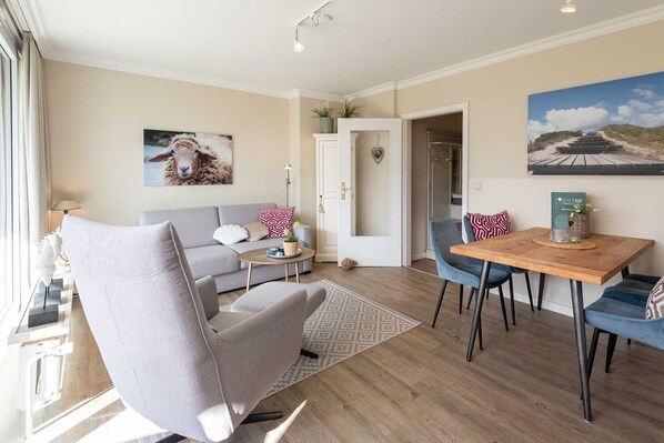 Un salon moderne avec un canapé gris, une table à manger en bois et une chaise bleue.