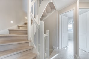 Una escalera con barandillas blancas que sube a un segundo piso.