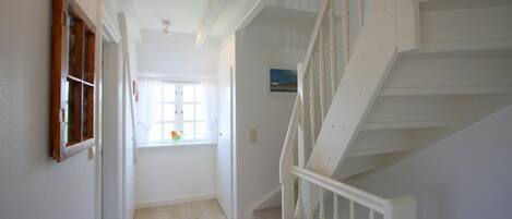 A staircase with white railings and a green bench at the bottom.