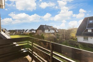 Un quartier résidentiel avec des maisons, un champ d’herbe et une clôture en bois.