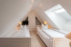 A bedroom with two beds, a TV, and a skylight. - Haus Gorch-fock-straße - Exklusives Hausteil mit ca. 120 m² und 5 Zimmern, für bis zu 4 Personen (Sylt)