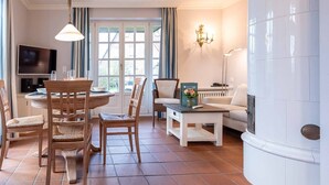 Un salon comprenant un coin repas, un canapé, un téléviseur et une cheminée.