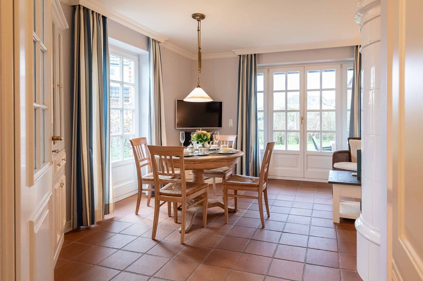Un coin repas avec une table ronde, des chaises et un téléviseur fixé au mur.