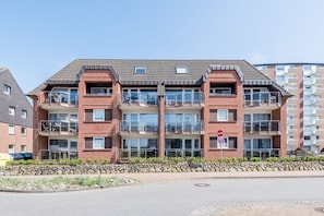 A multi-story residential building with balconies, a stone facade, and a clear sky. - Haus Atrium Apartment 19 - Cozy 2-room vacation apartment with approx. 45 m², for (Sylt)