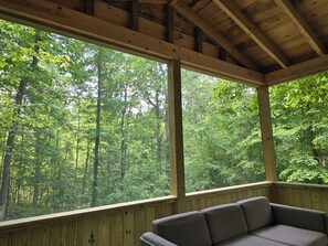 A wooden cabin with large windows offering a view of a dense forest. - Nolin Cabin Experience w/ Hot Tub (Grayson County)