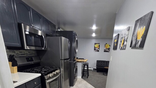 A compact kitchen with dark cabinets, stainless appliances, and a tiled floor. - Private 1 bedroom apt in a quiet neighborhood, close to all! (Centereach)