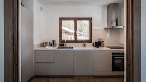 Pieni keittiö, jossa on ikkuna, liesi ja astianpesukone.