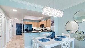 A modern kitchen with white cabinetry, a central island, and a chandelier.