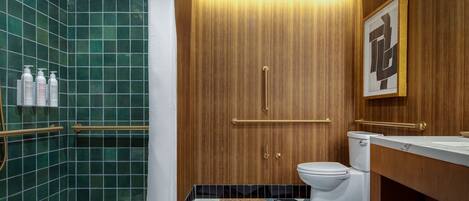 Un baño con ducha, inodoro y tocador.