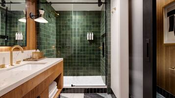 Un baño moderno con un espejo grande, un mueble de tocador doble, una zona de ducha y un armario de madera.
