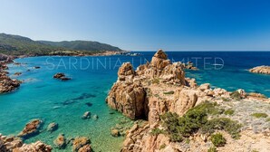 Un paysage côtier caractérisé par un terrain rocheux et des eaux d’un bleu limpide.