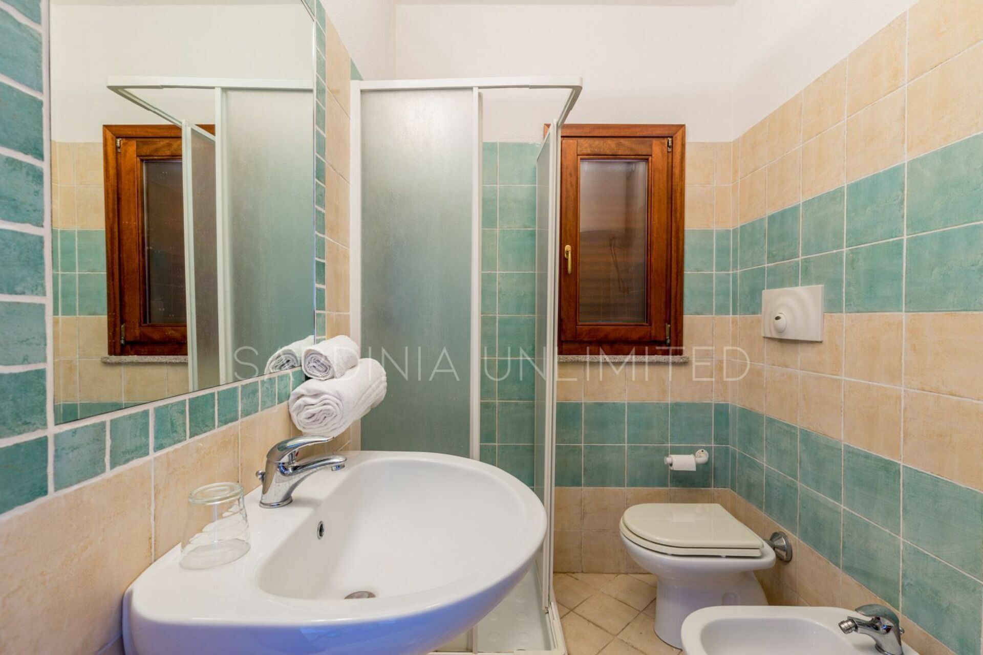 A bathroom with a sink, mirror, toilet, and shower.
