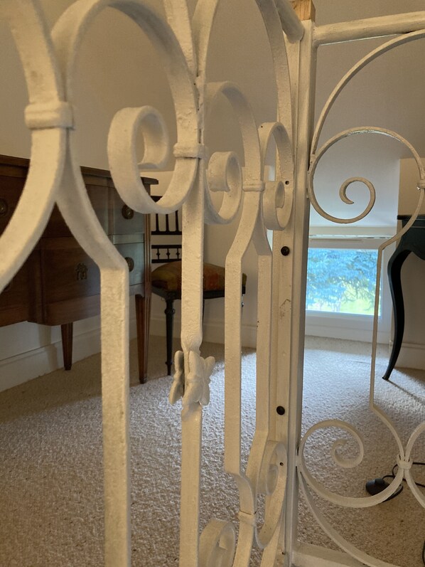 A room with a white metal bed frame, a wooden dresser, and a window with a view of trees. - Private Room in a Charming Estate (Le Compas)