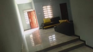 Relax in this serene space with a sofa and a door leading to more.