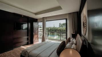 Un dormitorio moderno con una cama grande, un televisor montado en la pared y un balcón con vistas a la piscina.