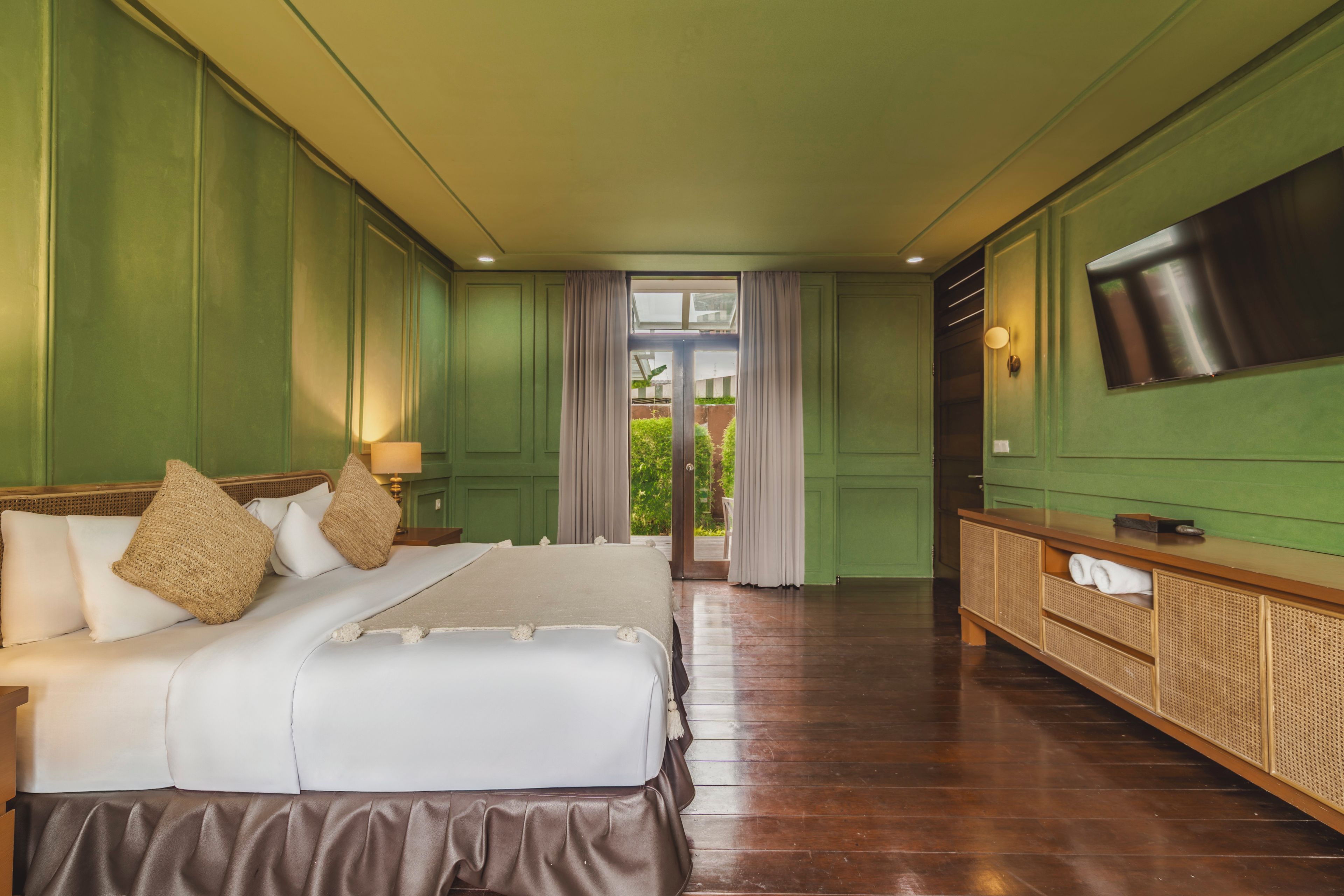 Una habitación de hotel con cama, televisión y vistas al exterior.