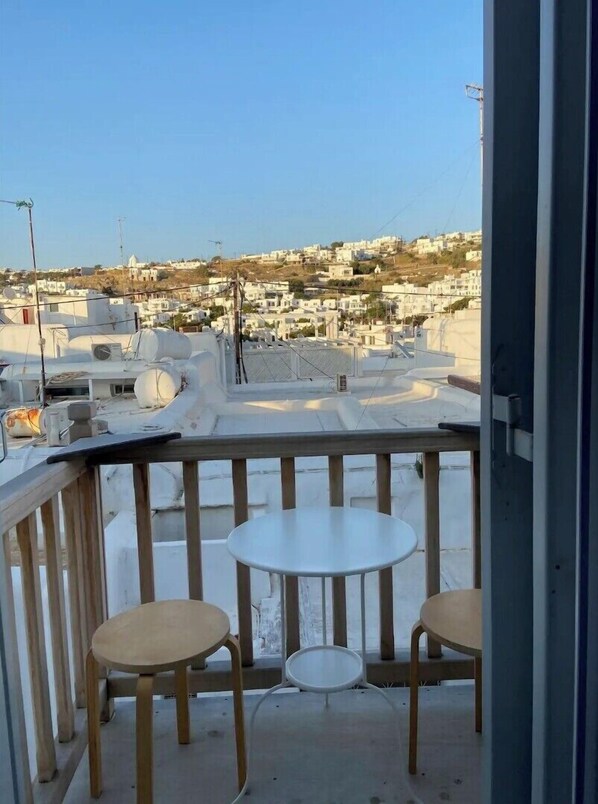 Enjoy a view of the surrounding neighborhood from this balcony with a dining area.