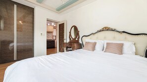 A hotel room with a large bed, a wooden dresser, and a mirror. - Gapyeong Maplein Pension (Gapyeong)
