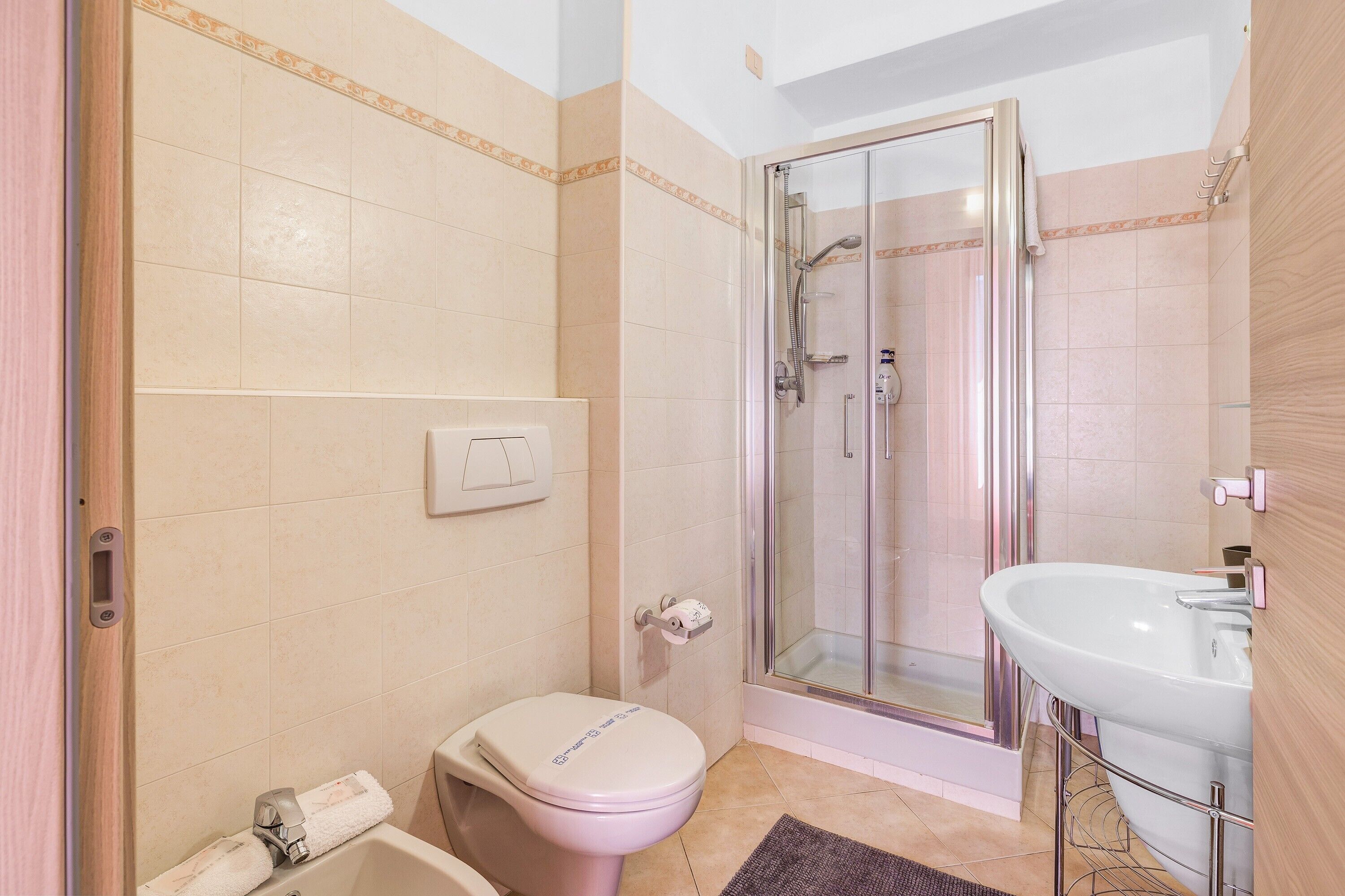 A bathroom with a toilet, shower, and sink.