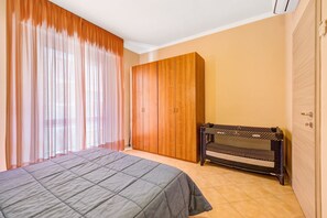 Un dormitorio con cama, armario y banco.