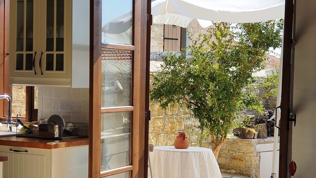 Una cocina con una puerta corrediza de vidrio que da a un patio al aire libre.